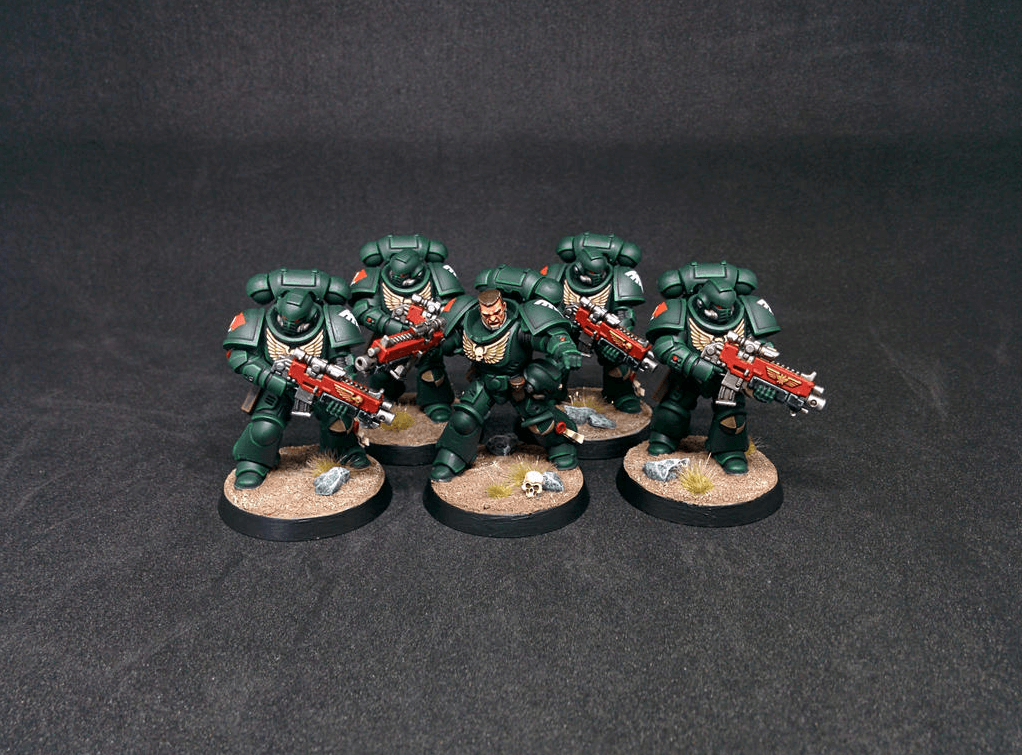 A squad of five Dark Angels Space Marines in green armor holding red boltguns.