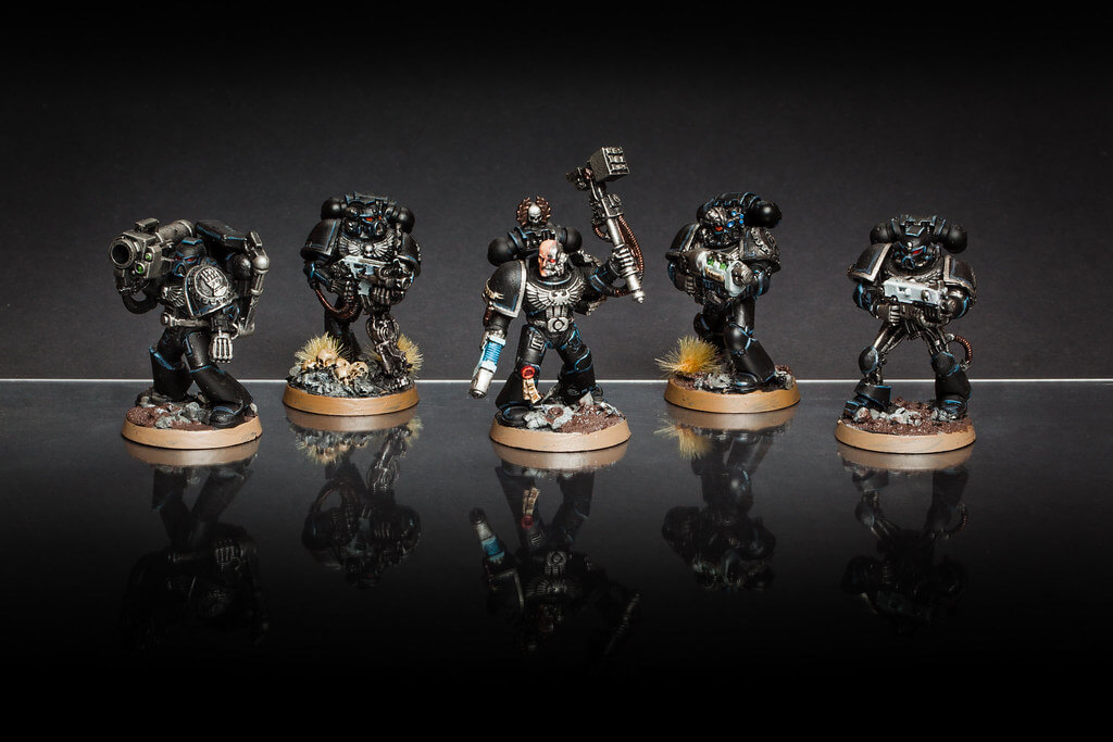 A group of five Iron Hands models in black armor, holding a variety of ranged weapons.