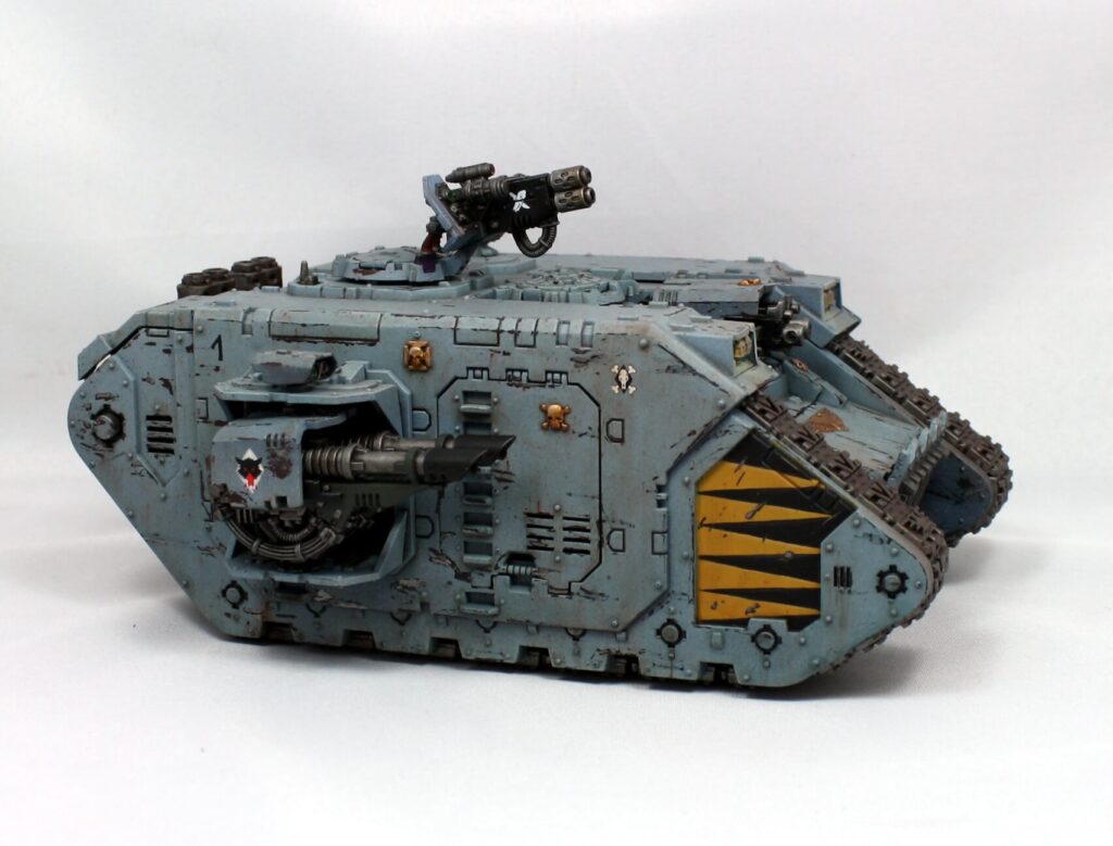 Space Wolves Land Raider tank in blue-gray with yellow accents and mounted weaponry.